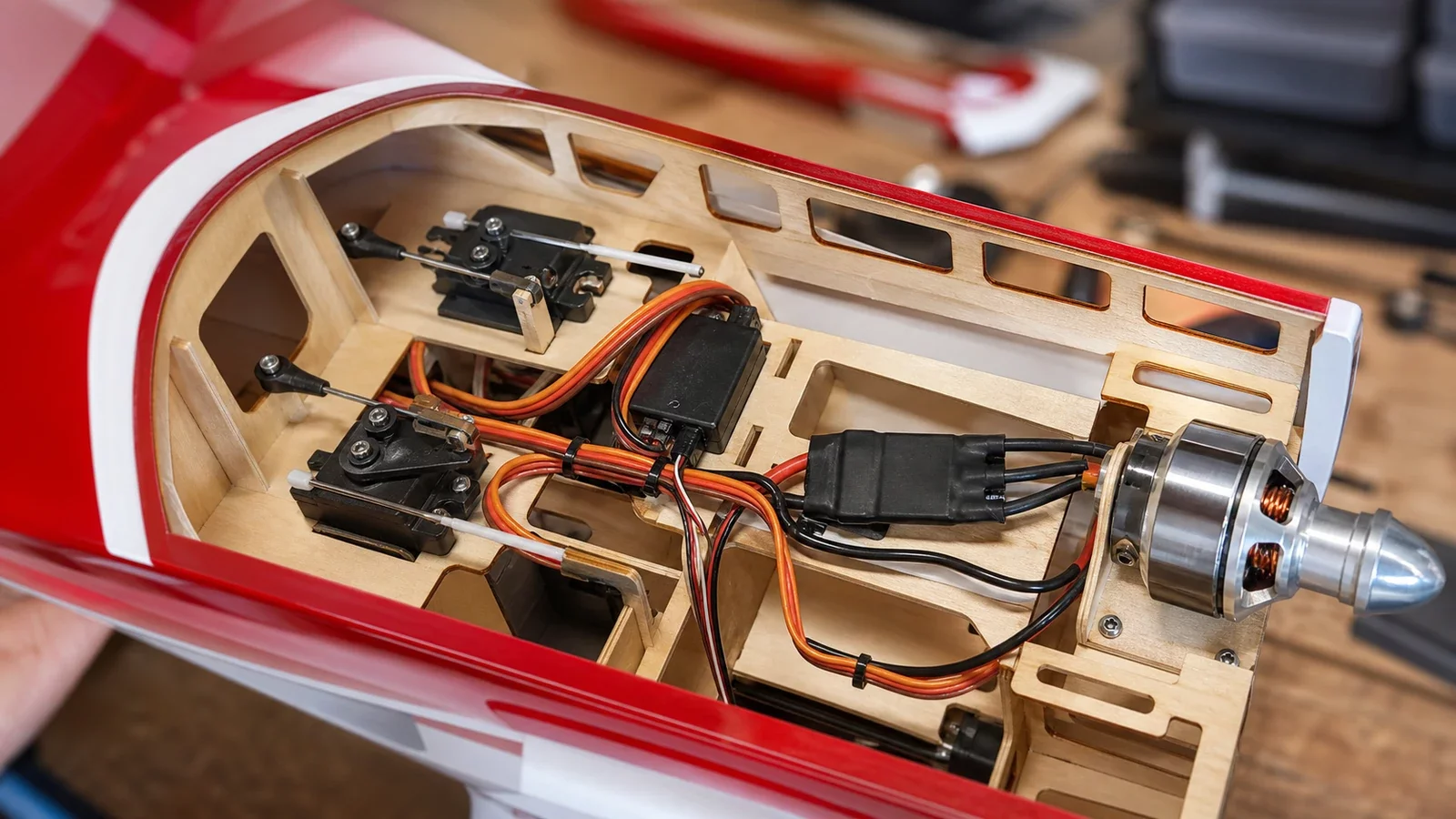 Gros plan sur les servos et le moteur brushless installés dans un fuselage d'avion télécommandé